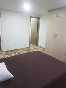 ein leeres Zimmer mit einem Bett und einer Tür in der Unterkunft APARTAMENTO AMOBLADO BARRIO LAS VIOLETAS in Pasto