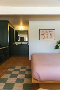 a bedroom with a pink bed and a bathroom at Hummingbird Inn in Ojai