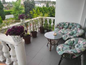 balcón con sillas, mesa y macetas en Usługi Noclegowe i Gastronomiczne dla Ludności Robert Mielcarek, en Kobyla Góra