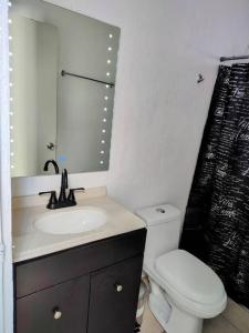 uma casa de banho com um lavatório, um WC e um espelho. em Casa Norte em La Paz