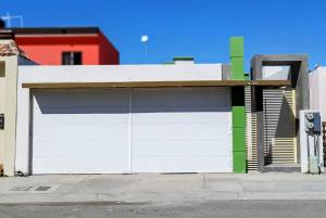 uma garagem com uma porta de garagem branca e verde em Casa Norte em La Paz