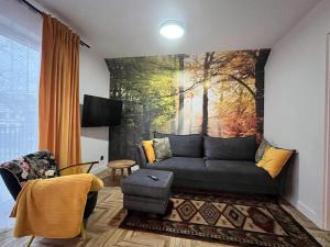 Apartamenty Bursztynowa 36 في نيخوجة: غرفة معيشة مع أريكة ولوحة على الحائط