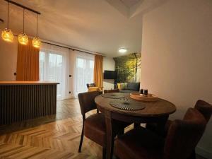 a living room with a table and a dining room at Apartamenty Bursztynowa 36 in Niechorze