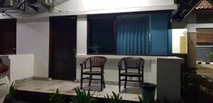 zwei Stühle auf der Veranda eines Hauses in der Unterkunft Hotel pondok putri in Batukaras
