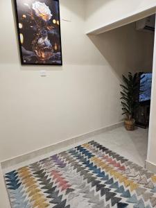 a room with a rug on a wall with a tv at شقة جود طيبة الفندقية Jood Taibah Luxury Apartment in Al Madinah
