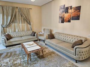 a living room with two couches and a table at شقة جود طيبة الفندقية Jood Taibah Luxury Apartment in Al Madinah