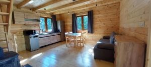 a living room with a couch and a table in a log cabin at Winiec 218/8 in Miłomłyn