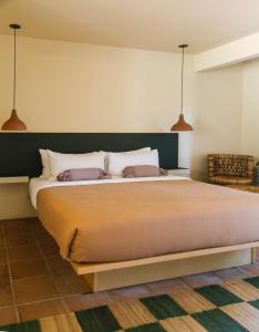 a bedroom with a large bed with two pillows at Hummingbird Inn in Ojai