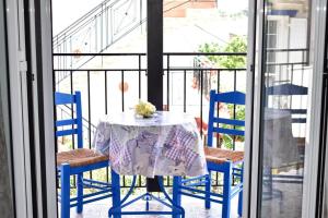 a table with two blue chairs and a table with a table cloth at Pansion Pandora in Skiathos Town