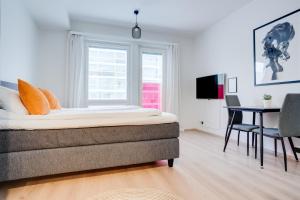 a bedroom with a bed and a table and a window at Lapin Loiste 1, Modern studio, Free Parking and Wifi in Rovaniemi