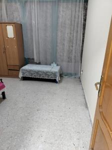 Hussaini Home في أبوظبي: غرفة نوم بسرير في غرفة مع ستائر