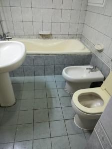 uma casa de banho com um lavatório, um WC e uma banheira em Hussaini Home em Abu Dhabi