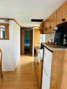 a kitchen with wooden cabinets and a counter top at Equi-lodge vert au coeur des chevaux & de la nature proche Disney avec possibilité de balade poneys in La Houssaye-en-Brie