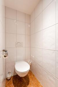 a white bathroom with a toilet and a shower at Hotel Restaurant Hexenalm in Söll