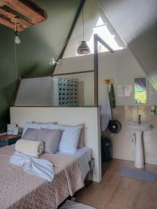 a bedroom with a bed and a sink in a attic at Flora Glamping de Abuela in Fortuna