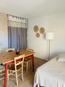 a dining room with a table and a bed at Charmant studio rénové 3 couchages Arcachon centre ville in Arcachon