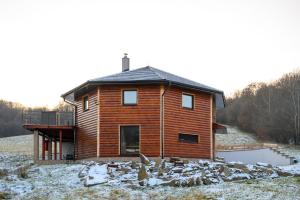 a wooden house with a pond in front of it at Chata Exit 