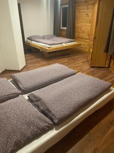 a room with two beds sitting on a wooden floor at Chata Exit 