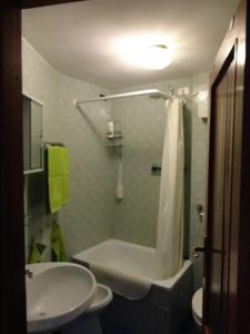 La salle de bains est pourvue d'une baignoire, d'un lavabo et d'une douche. dans l'établissement Cervinia-Valt Sport & Relax House, à Valtournenche