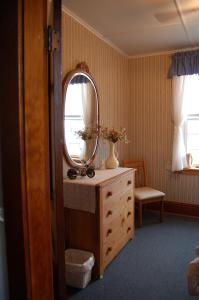 ein Badezimmer mit einem Waschbecken und einem Spiegel auf einer Kommode in der Unterkunft The Yellow Sidecar B&B in Cap Le Moine