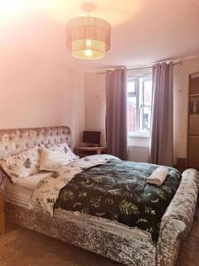 a bedroom with a bed with a couch and a window at Lovely, spacious 1-bedroom apartment with *free parking in Manchester