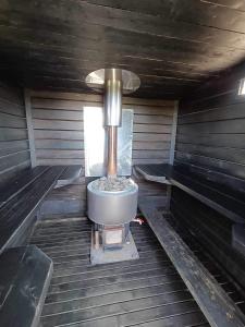 eine Innenansicht einer Sauna mit Ofen in der Unterkunft Elämyksellinen majoitus farmilla in Kälviä + 24 Fotos