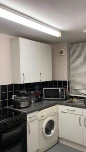 cocina con lavadora y microondas en Lovely, spacious 1-bedroom apartment with *free parking en Mánchester