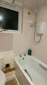 y baño con bañera, ducha y aseo. en Lovely, spacious 1-bedroom apartment with *free parking en Mánchester