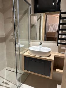 a bathroom with a sink and a glass shower at Rezidencia Hrabovo SKI IN-OUT in Ružomberok