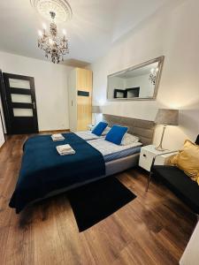 a bedroom with a large bed and a mirror at Apartament Zdrój Lądek in Lądek-Zdrój