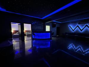 ein Wohnzimmer mit blauer Beleuchtung und einer Couch in der Unterkunft شاليهات يارا القيروان in Riad