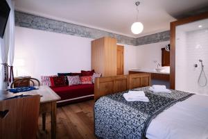 1 dormitorio con cama, sofá y mesa en Pr'Gavedarjo Eco Heritage B&B, en Kranjska Gora