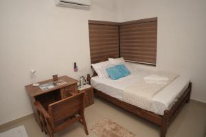 a bedroom with a bed and a desk with a telephone at Happy Villa Homestay in Chelakara