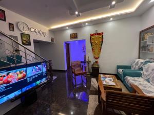 a living room with a couch and a tv at Happy Villa Homestay in Chelakara