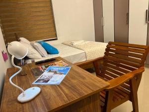 a room with a table with a bed and a lamp at Happy Villa Homestay in Chelakara