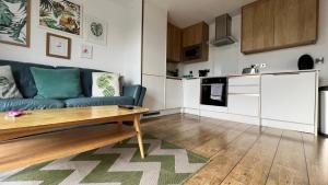 a living room with a blue couch and a kitchen at Stunning Flat in Hull's Vibrant Fruit Market & Marina in Hull