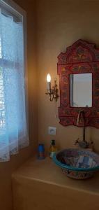 a bathroom with a bowl sink and a mirror at Jolie propriété de campagne calme et spacieuse 