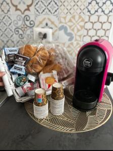 B&B Queen's Luck في إيركولانو: طاولة مع آلة صنع القهوة وسلة من الطعام
