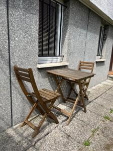 a wooden table and chairs sitting next to a building at Cozy apartment in Ljubljana - Free parking in Ljubljana