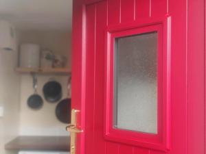 a pink door with a window in a kitchen at The Home House in Plumb Bridge