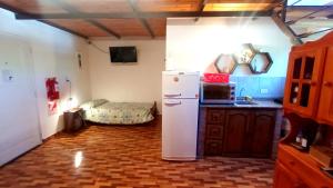 cocina con nevera y 1 cama en una habitación en Cabañas Caranday en Capilla del Monte