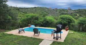 una piscina con 2 sillas y TV. en La più bella en Villa Carlos Paz