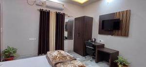 Mandakini Homestay في فاراناسي: غرفة معيشة بها أريكة وتلفزيون في غرفة