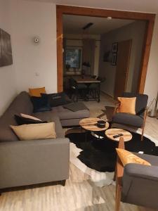 una sala de estar con sofás, mesas y un piano en Luchshuette, en Sankt Andreasberg