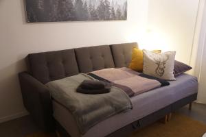 um sofá com almofadas e um cobertor em Ferienwohnung Inheiden - Auszeit in Seenähe em Hungen