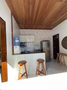 een keuken met 2 krukken en een aanrecht bij Small house in Ilha de Boipeba