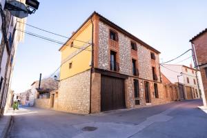 un viejo edificio de ladrillo con una puerta en una calle en Casa del Agüelo, en Cella
