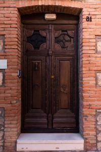 una gran puerta de madera en un edificio de ladrillo en Casa del Agüelo, en Cella