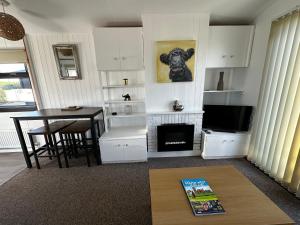 a living room with a table and a fireplace at Ardbeg 4 - Farm Stay with Sea Views across to Northern Ireland in Stranraer