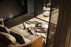 a room with a bed and a chair with a phone on it at ASTER Boutique Hotel & Chalets in Fügenberg